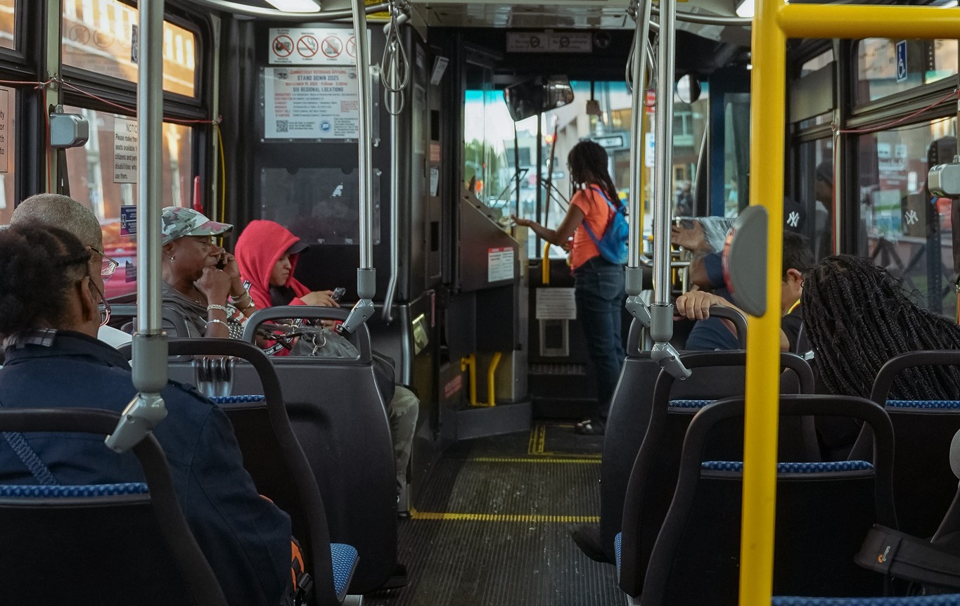 A young woman pays her fare as she boards a bus